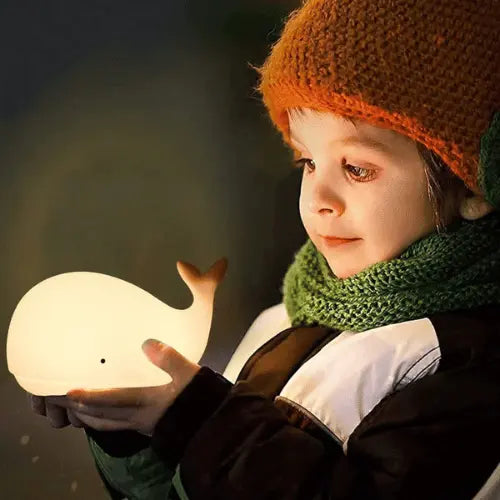 Enfant tenant une veilleuse baleine LED lumineuse, lampe de nuit douce et rassurante pour bébé et enfant.