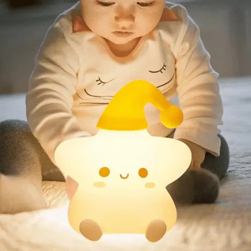 Veilleuse étoile LED douce, bonnet jaune, tenue par un bébé, lumière rassurante pour la nuit