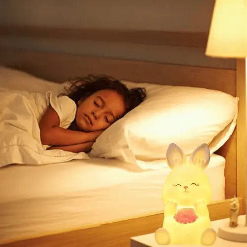 Enfant qui dort paisiblement grâce à une veilleuse lapin douce et rassurante, idéale pour bébé, chambre d’enfant et nuits sereines.